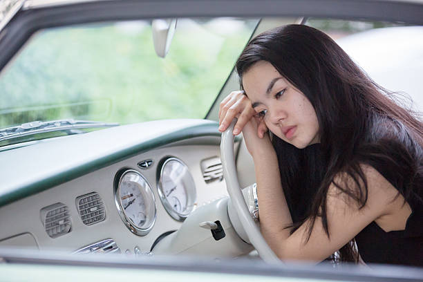 Asian lady smiling in a vintage car