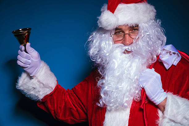 istock Santa Claus holding a bell in his right hand 521232821
