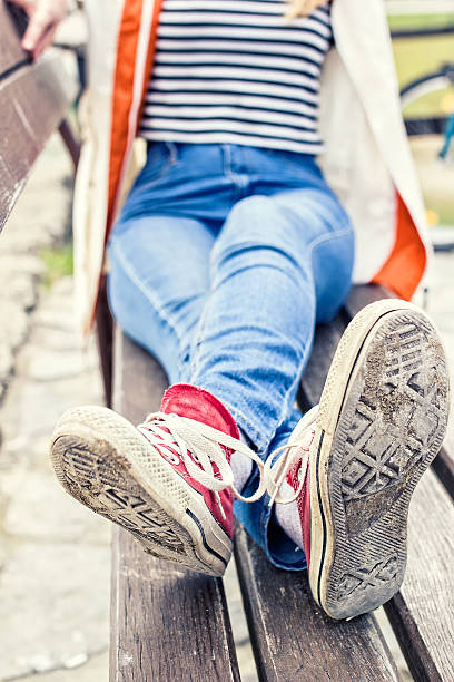 istock Woman's legs wearing red canvas sneakers 521237102
