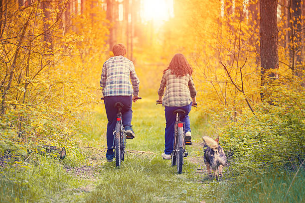 Young happy couple ride bicycles in the forest
