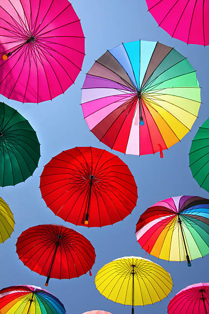 istock Collection of multi colored umbrellas hanging up. 521245701