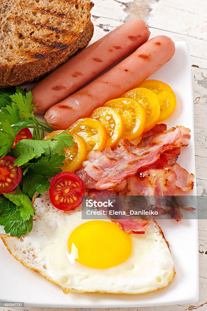 English breakfast English breakfast - fried eggs, bacon, sausages and toasted rye bread Bacon Stock Photo