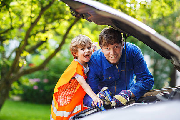 istock Young father teaching his little son repairing car 521249093