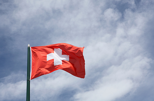 Flag of Switzerland on a sky and clouds