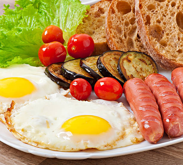 istock English breakfast - fried eggs, sausages, eggplant and tomatoes 521249973
