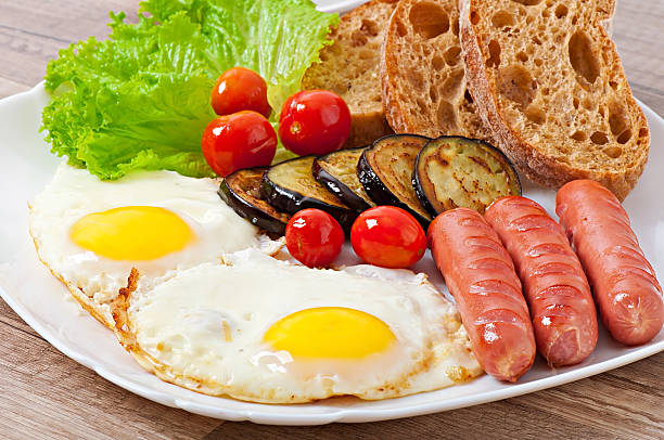 istock English breakfast - fried eggs, sausages, eggplant and tomatoes 521249975