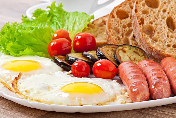 istock English breakfast - fried eggs, sausages, eggplant and tomatoes 521249977