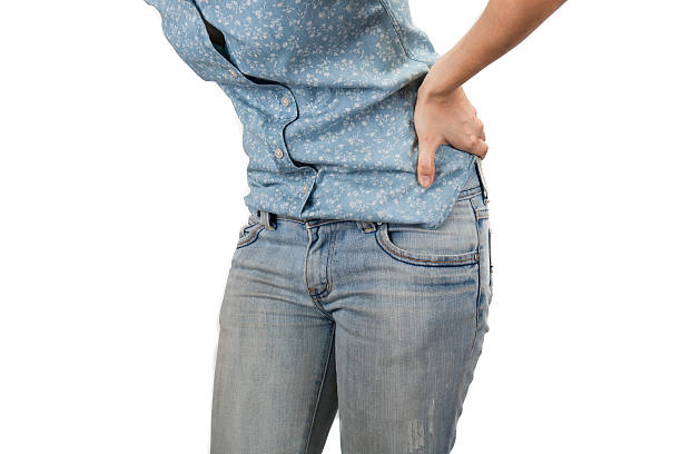 istock woman holding hands to his aching back 521261072