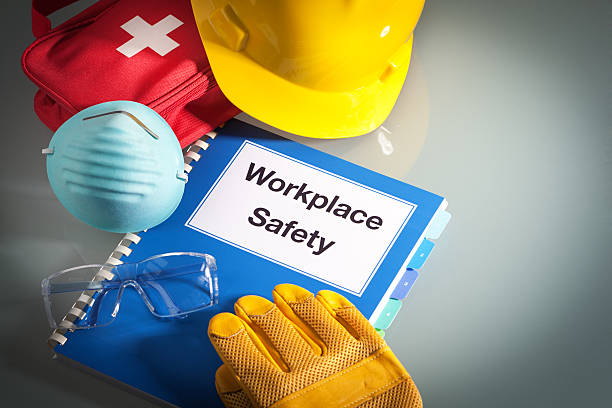 Workplace Safety Handbook Manual and Occupational Equipment for Work Training Workplace safety handbook with occupational safety equipment still life, a work training class and instruction manual for using safety equipment and administering first aid. Employment education document with protective eyewear, hard hat, first aid kit, work glove, and pollution mask. Guidance and planning tools in horizontal format with copy space. occupational safety and health stock pictures, royalty-free photos & images
