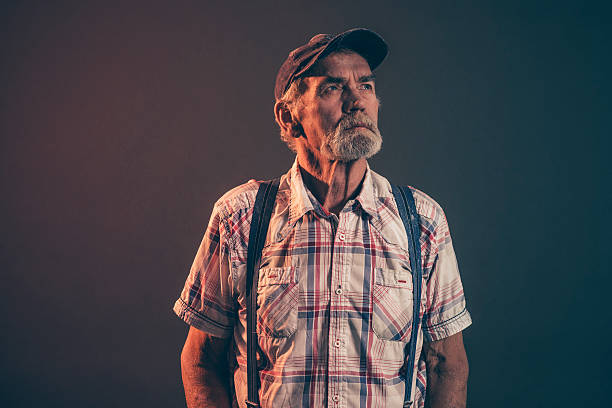 istock Characteristic man with gray hair and beard wearing blue cap. 521261675