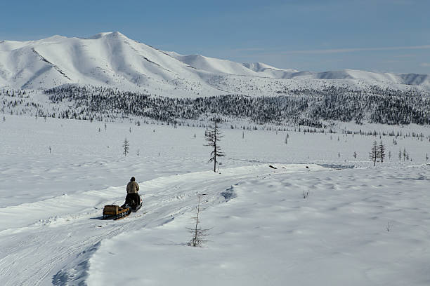 istock Man riding a snowmobile in the mountains. 521261688
