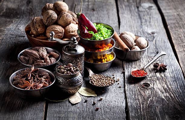 especias y frutos secos en una mesa de madera - nutmeg india spice nut fotografías e imágenes de stock