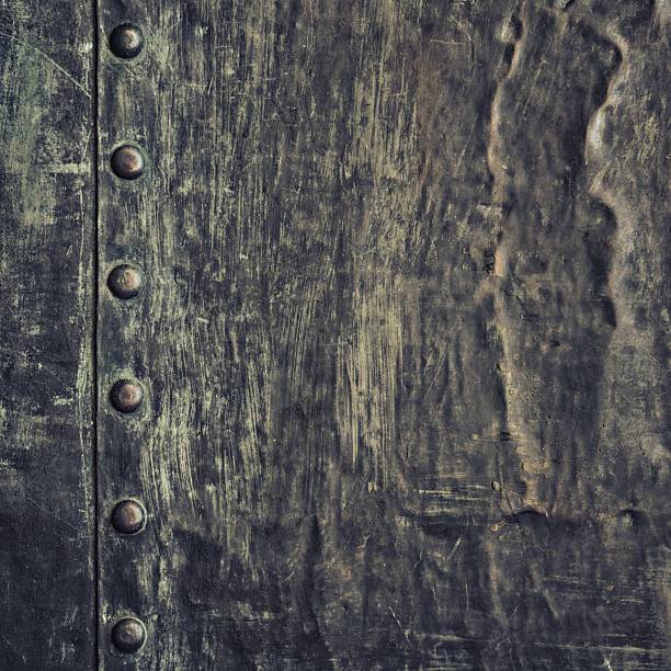 istock Grunge black metal plate with rivets screws background texture 521262889
