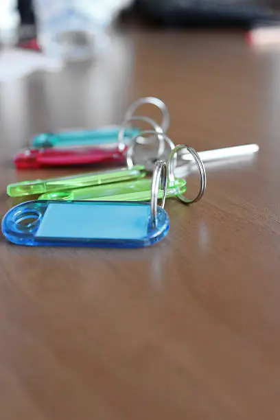 Close up on several colorful keyholders on a office desk