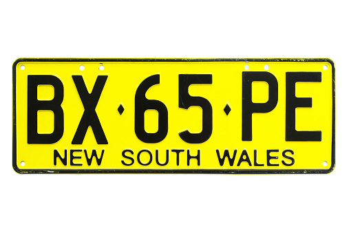 Sydney, Australia - October 11, 2014: An expired New South Wales vehicle license plate with the letters BX65PE, isolated on a white background. The black letters on yellow plate style is one of the current formats adopted.