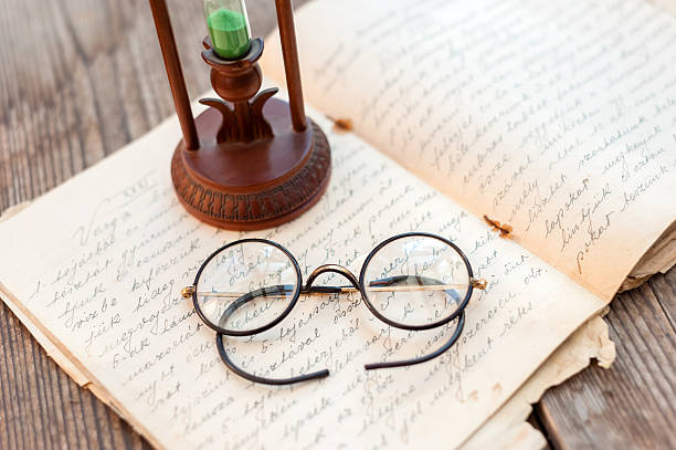 Vintage book, glasses and watches on the background of a wooden wall. Retro concept