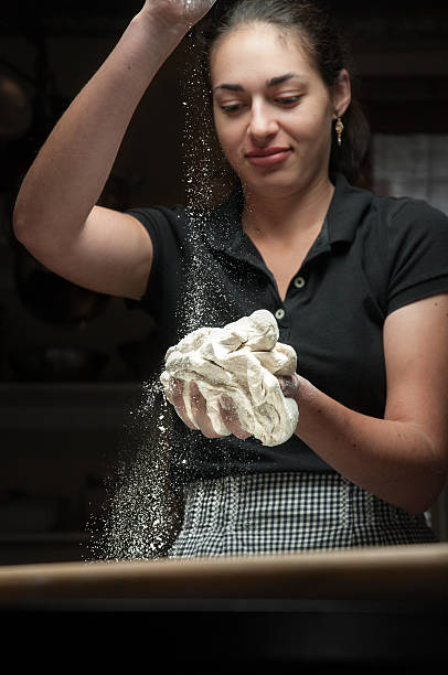 istock Young woman adding flour to dough 521266955
