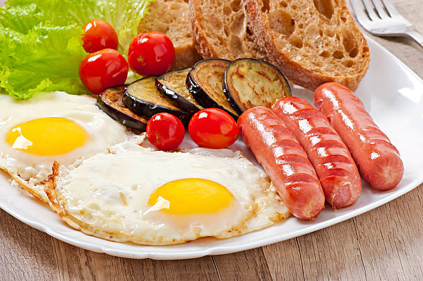 istock English breakfast - fried eggs, sausages, eggplant and tomatoes 521267869