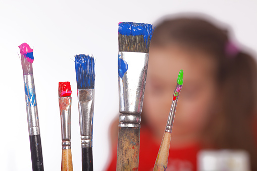 Picture of colorful painting utensils .The Girl in the background is unsharp. Short focus picture. Bokeh.