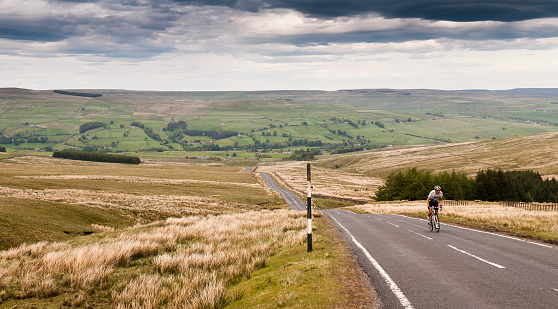 Durham, England - May 25, 2011: A road cyclist climbs Chapel Fell, the hill dividing Weardale and Teesdale in England's remote North Pennines hills.
