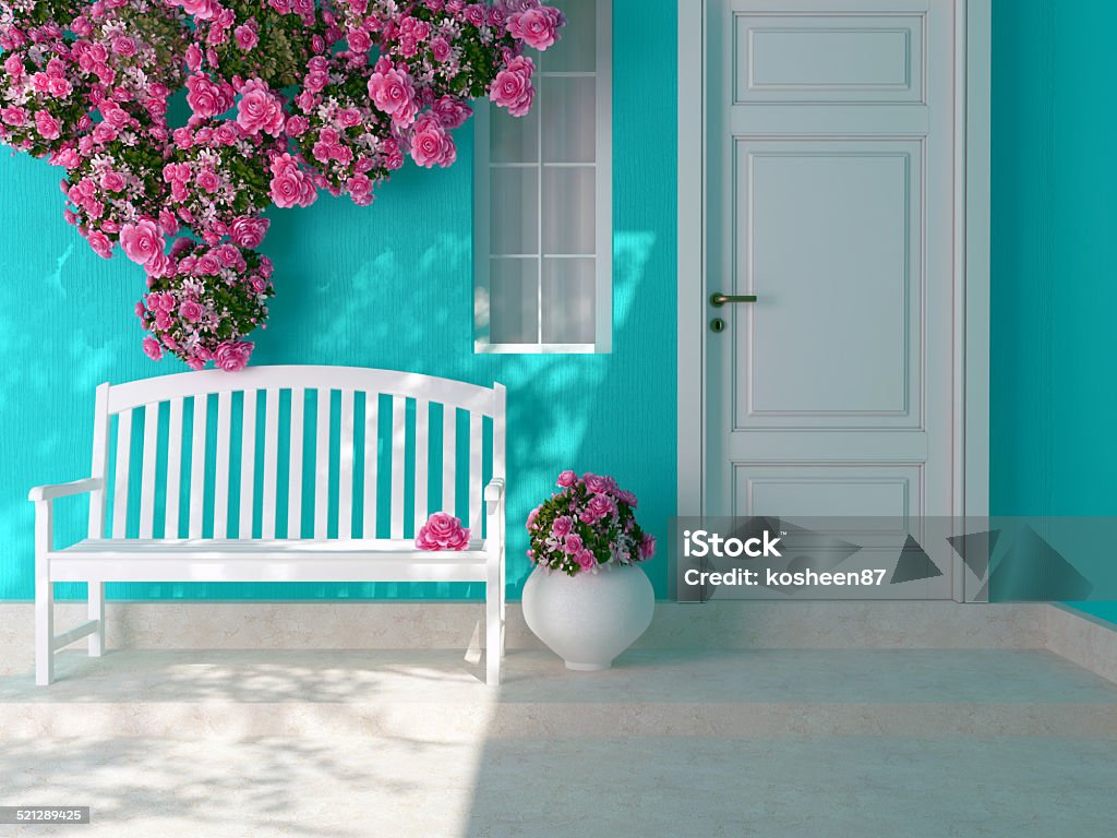 Entrance of a house. Front view of a wooden white door on a blue house with window. Beautiful roses and bench on the porch. Entrance of a house. Outdoors Stock Photo