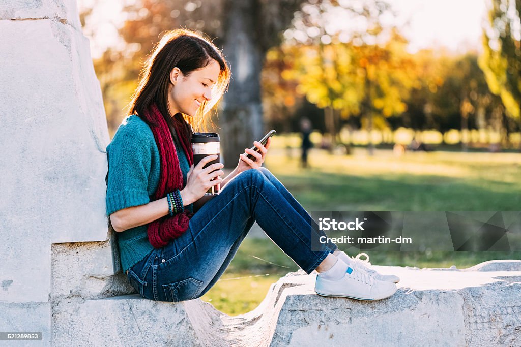 Girl with phone in the park Young girl in the park 20-29 Years Stock Photo