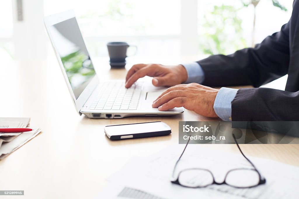 Businessman using computer on the office table in the office Adult Stock Photo