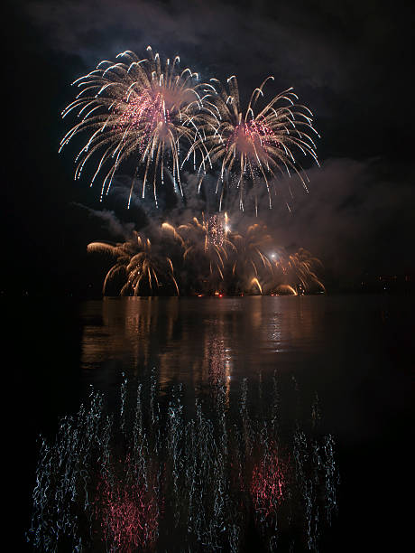 istock Colorful fireworks on black sky background with water reflections 521291209