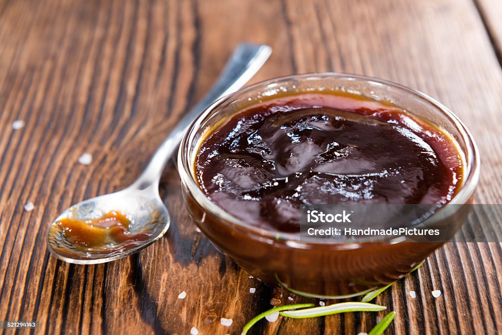 Barbeque Sauce Barbeque Sauce with Tomatoes, Smoked Salt and fresh Herbs (on rustic wooden background) Barbeque Sauce Stock Photo