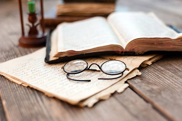 istock Close-up of opened book pages and glasses 521294433
