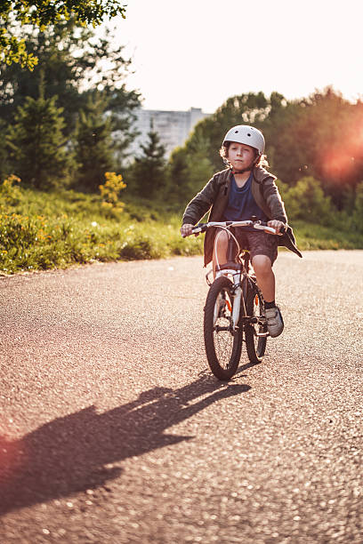 istock Cute Boy Riding a Bike in the Park 521299630