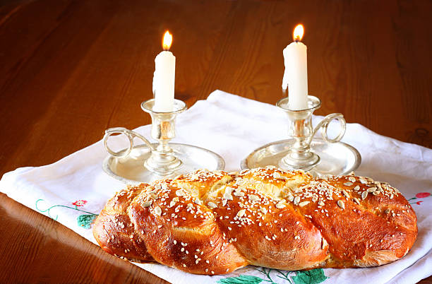 istock shabbat image. challah bread, shabbat wine and candelas on woode 521301326