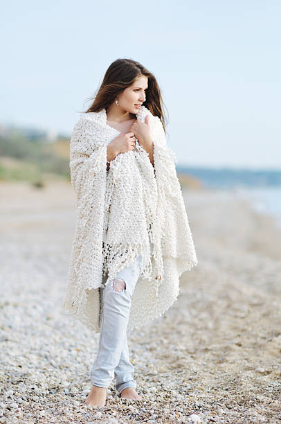 istock the young woman standing on a beach in a blanket 521301360