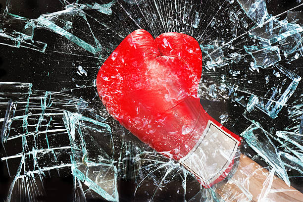 Boxing through glass window. Boxing glove through broken glass window. knockout stock pictures, royalty-free photos & images