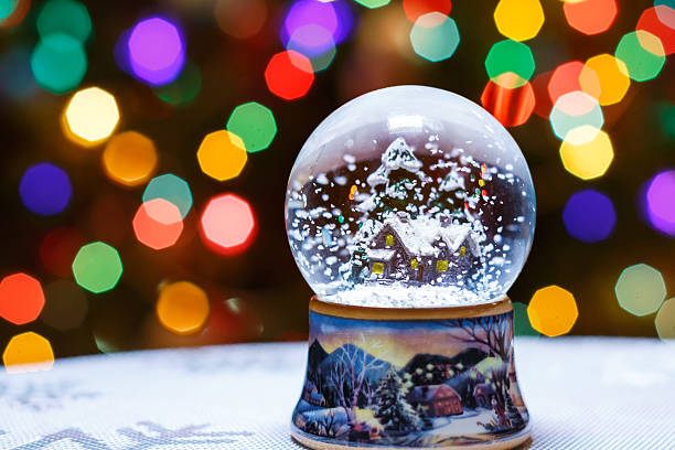 natale neve globo di fronte a luci albero di natale primo piano - luminant foto e immagini stock