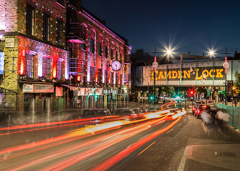 London, UK - July 17, 2015: The outside of buildings and a bridge in Camden Lock at night. The trails of traffic can be seen.