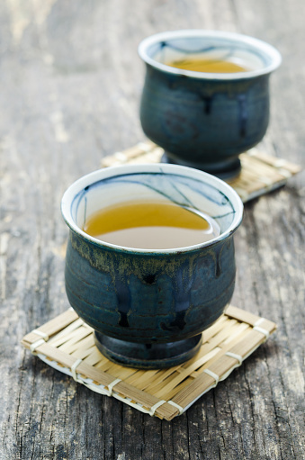 Cup of Japanese green tea on old wooden table