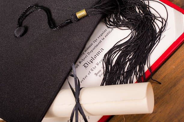 istock Graduation!  Cap, motarboard and tassel with dilplomas on table. Education. 521310908
