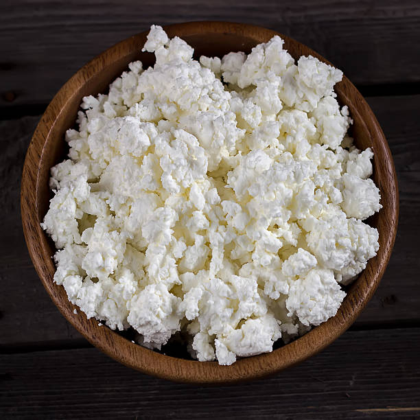 istock Cottage cheese in a bowl on wooden table. 521310966