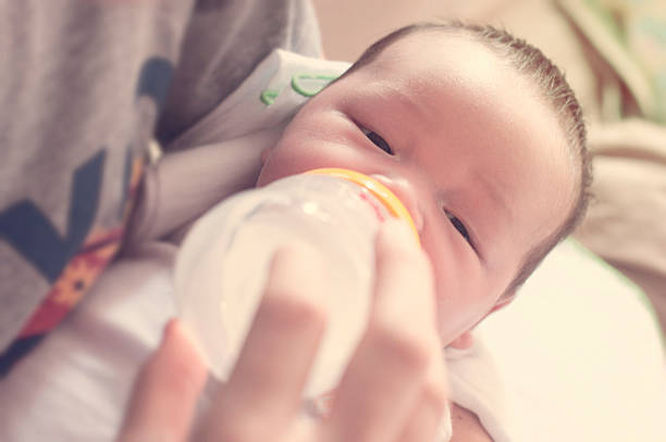 istock Young father feeding baby boy with milk bottle 521311516