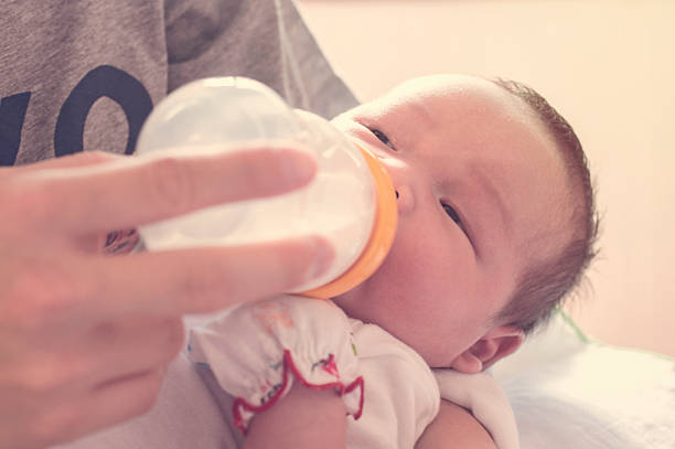 istock Young father feeding baby boy with milk bottle 521311544