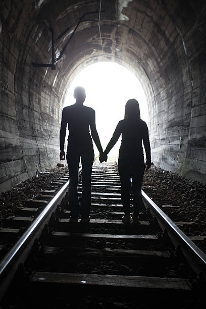 istock Couple walking together through a railway tunnel 521311548