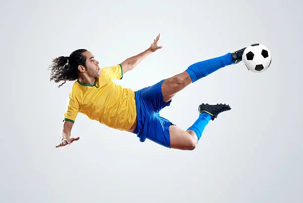 soccer player kicking ball towards goal for score and glory