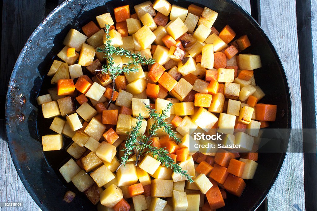 Fried dices of carrot and swede Fried dices of carrot and swede, in a pan + thyme Rutabaga Stock Photo