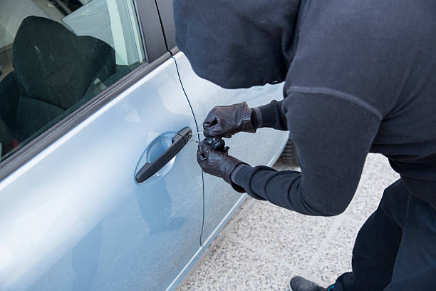 istock Car thief using  special tools to brake into a car 521316349