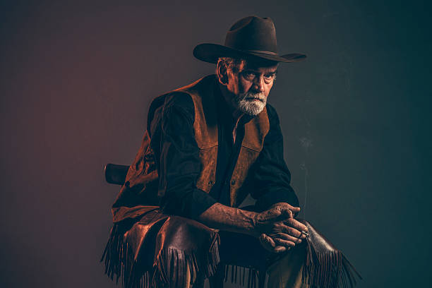 istock Cigarette smoking old rough western cowboy with gray beard. 521318967