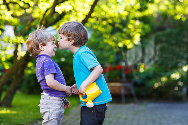 istock Two little sibling boys hugging and having fun outdoors 521319505