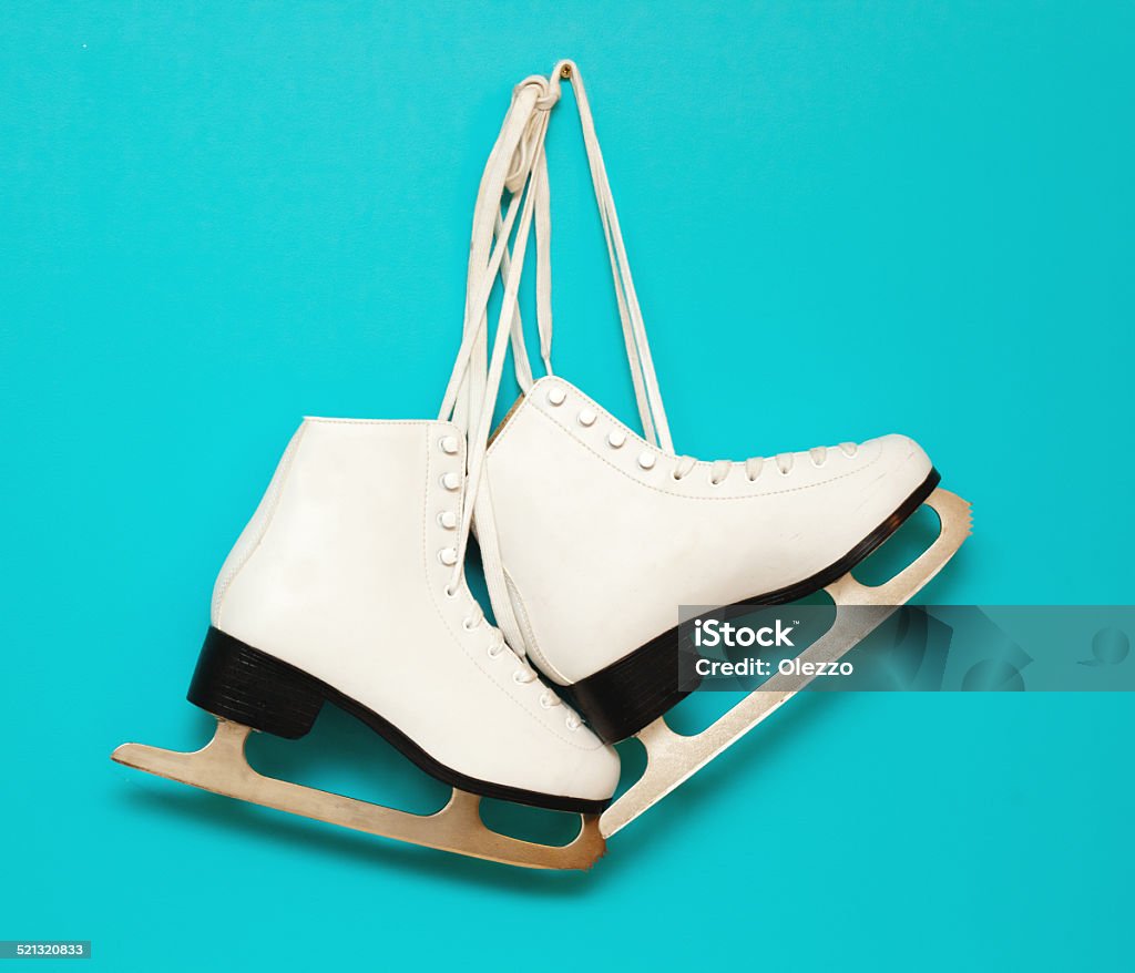 white ice skates for figure skating white ice skates for figure skating, hanging on a blue background Ice Skate Stock Photo