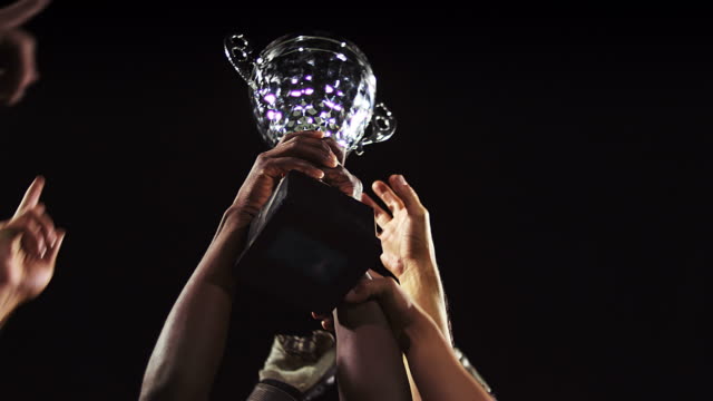 A trophy being held in the air by a sports team