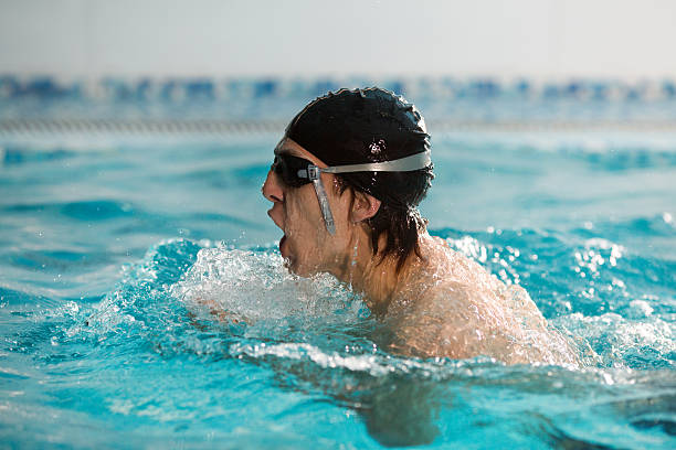 junger mann schwimmen. - breaststroke stock-fotos und bilder